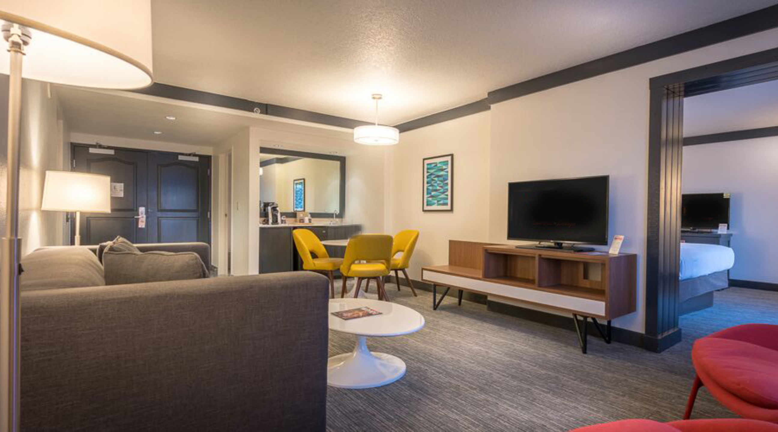 Living room, pull out sofa, flat screen TV, table and chairs.